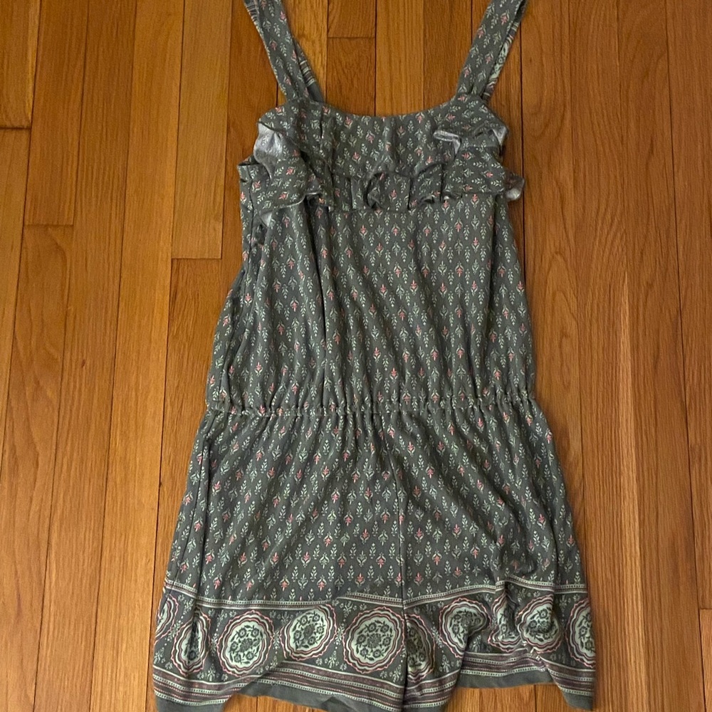 Green romper with pattern.